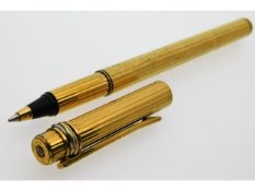 A Cartier gold plated ball point pen with three colour gold plated band to top, some wear & bump to