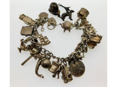 A silver charm bracelet with three loose charms, 1