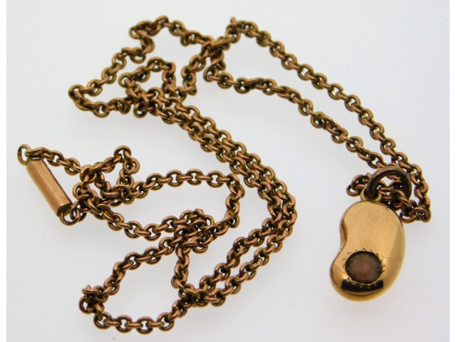 A 1920's 9ct gold chain with a Victorian yellow metal kidney bean shaped pendant set with coral, ele