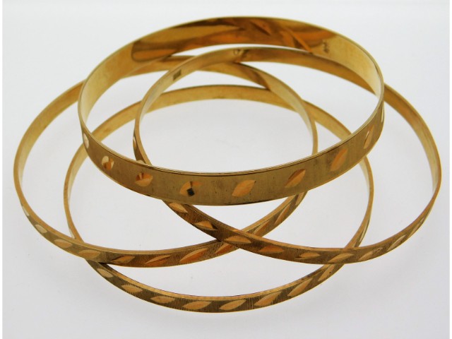 Four yellow metal bangles, test as 20ct gold, 50.79g