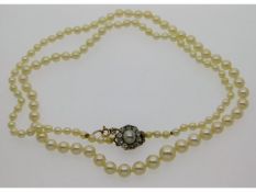 A set of cultured pearls with a 19thC. 9ct clasp set with approx. 0.5ct of old cut diamonds & a cent