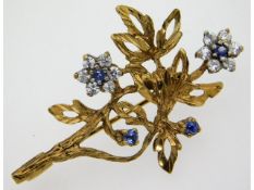 A 9ct gold brooch of organic form set with approx.