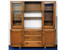 An Ercol elm sideboard with glazed cupboards over