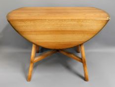 An Ercol elm drop leaf dinner table with four chai