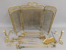 A pair of brass firedogs, a brass companion set &