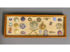 A cased selection of mixed badges & buttons includ