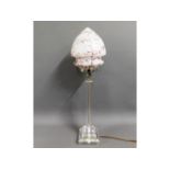 A decorative resin table lamp with glass shade