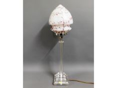 A decorative resin table lamp with glass shade