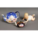 A German bisque porcelain model of crawling baby, 7in long, twinned with two antique teapots with Ch