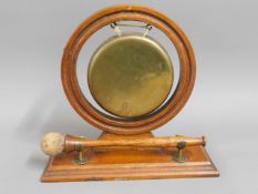 An early 20thC. oak mounted brass gong, 8.25in hig