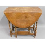 A 1920's oak drop leaf table with barley twist sup