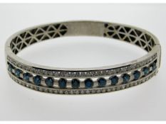 A 14ct white gold bangle set with 7.25ct of blue &