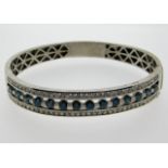 A 14ct white gold bangle set with 7.25ct of blue &