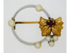 A yellow & white metal brooch set with pearl & rub