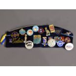 A cap with a quantity of vintage badges including