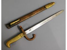 A c.1900 brass handled bayonet with crest on hilt,