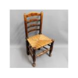 A 19thC. rush seated oak ladderback chair, 36.5in