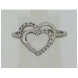 A 9ct white gold ring with heart shape decor set w
