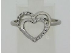 A 9ct white gold ring with heart shape decor set w