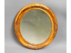 A decorative antique gilt wood oval mirror, some l