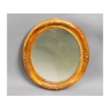 A decorative antique gilt wood oval mirror, some l