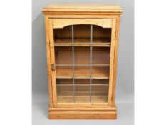 An antique pine bookcase with shelves & leaded gla