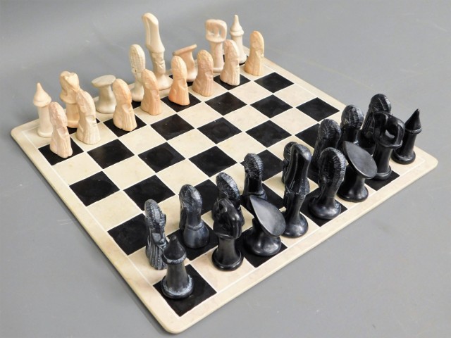 A carved stone African chess set with marble type