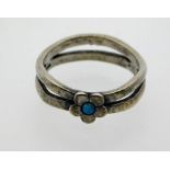 An antique silver ring set with small black opal,