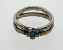 An antique silver ring set with small black opal,