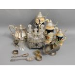 A silver plated teapot, a plated condiment set, th