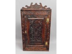 A 19thC. carved oak corner cupboard with brass fit