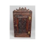 A 19thC. carved oak corner cupboard with brass fit