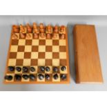 A carved wood chess set, King 4.5in tall, board 17