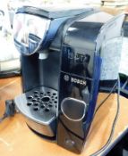 A Bosch Tassimo coffee maker with glass stand