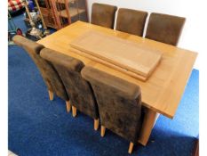 A modern sold light oak extending dining table wit