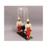 A figurative spelter style candle holder with glas