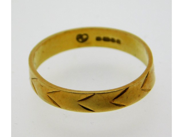 An 18ct gold band with chevron decor, size O/P, 2.