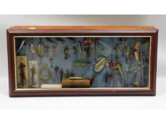 A cased display of vintage lures including Allcock