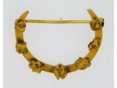 A 15ct gold crescent shaped brooch with "nugget" d