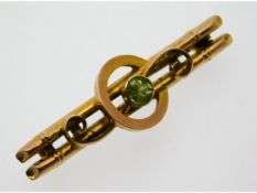 An antique 9ct gold brooch set with peridot, 37mm