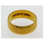 A 22ct gold band with floral decor, size Q/R, 6.59