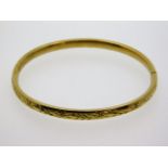 A 9ct gold bangle with chased decor, 59mm internal