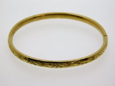 A 9ct gold bangle with chased decor, 59mm internal