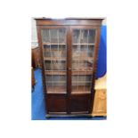 An oak bookcase with leaded glass doors, 73in x 38