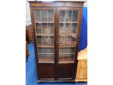 An oak bookcase with leaded glass doors, 73in x 38