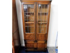 An oak glass fronted bookcase with shelves & cupbo