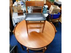 An extending vintage retro teak table with four ch