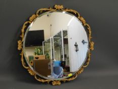 A decoratively framed circular mirror, 20in diamet