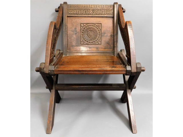 An oak Glastonbury chair with carved decor & scrip