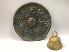An antique bronze disc with figurative moulded dec